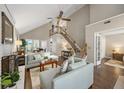 Bright living room boasts a vaulted ceiling, wood floors, a brick fireplace, and a staircase to the second level at 302 Roswell Green Ln, Roswell, GA 30075