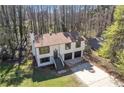 Aerial view of a two story house with a nice sized yard and many trees at 5075 S Woodbridge Trl, Stone Mountain, GA 30088