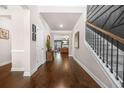 Inviting foyer with hardwood floors, a staircase featuring decorative trim, and an open view to the living room at 6441 Oakhurst Pl, Fairburn, GA 30213