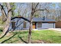 Attractive one-story home featuring gray siding, a well-kept lawn, and complemented by mature trees at 8212 Englewood Trl, Riverdale, GA 30274