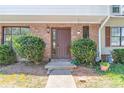 Close-up of a brick home's entryway, featuring a brown front door and manicured green bushes at 2090 Sand Wedge Nw Cir, Kennesaw, GA 30144