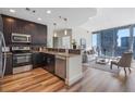 Modern kitchen featuring dark cabinets, stainless steel appliances, granite countertops, and an open living space at 1080 Peachtree Ne St # 2005, Atlanta, GA 30309