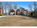Charming brick home with a manicured lawn and an attached two-car garage at 1129 Annie Sw Ln, Mableton, GA 30126