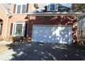 Front exterior view of attached two-car garage with white door on brick home at 2335 Corbett Ct, Powder Springs, GA 30127