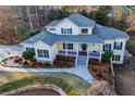 Aerial view of a charming yellow home with green shutters, mature trees and a manicured lawn at 7364 N Mitchell N Ct, Villa Rica, GA 30180
