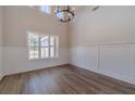 Dining room with wood floors, wainscoting, large window, and chandelier under a high ceiling at 215 Pinewood Dr, Covington, GA 30014