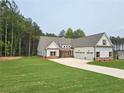 Spacious newly built home featuring a three-car garage, manicured lawn and professional landscaping at 215 Pinewood Dr, Covington, GA 30014