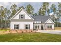 Charming white home with black shutters, a gabled roof, and a lush green lawn at 215 Pinewood Dr, Covington, GA 30014