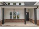 Inviting front porch with dark wood columns and black door, offering a charming entryway at 215 Pinewood Dr, Covington, GA 30014