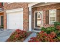 Close-up of townhome entrance with attached garage, featuring colorful landscaping at 2411 Heritage Park Nw Cir # 14, Kennesaw, GA 30144