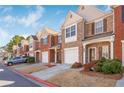 Street view of brick townhomes featuring individual garages and landscaped front yards at 2411 Heritage Park Nw Cir # 14, Kennesaw, GA 30144