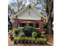 Charming brick home with beautiful landscaping, a welcoming arched porch, and mature trees at 1670 Rogers Sw Ave, Atlanta, GA 30310