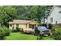Charming single-story house featuring a screened-in porch, a truck and trailer in the driveway at 514 Glendale Rd, Scottdale, GA 30079