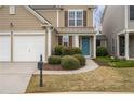 Attractive home exterior with well-maintained landscaping, a blue door, and a two-car garage at 271 Balaban Cir, Woodstock, GA 30188