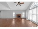 Spacious living room featuring a brick fireplace, hardwood floors, and large windows at 4142 Huntcliff Dr, Woodstock, GA 30189