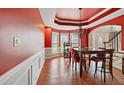 Elegant dining room with red walls, chandelier, and natural light from the bay windows at 1536 Granby Ln, Locust Grove, GA 30248
