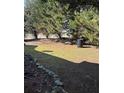 View of the backyard with shade trees and a bit of lawn space bordered by decorative stones at 413 Remington Ct, Villa Rica, GA 30180