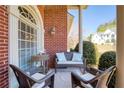 Comfortable porch seating and elegant decor complements the brick exterior of the home at 8005 Sweet Creek Rd, Johns Creek, GA 30097