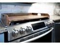 Stainless steel stove with wooden serving tray and a marble backsplash at 510 Coventry Rd # 8A, Decatur, GA 30030