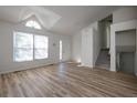 Living room with vaulted ceilings, wood floors, large windows, and view of the front entrance and staircase at 6136 Marbut Rd, Lithonia, GA 30058