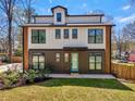 Modern farmhouse exterior with black framed windows, neutral siding, tidy front yard, and wood accents at 3087 Alston Dr, Decatur, GA 30032
