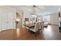 An open-concept dining room featuring hardwood floors, a modern chandelier, and plenty of natural light at 3030 Westpoint Cir, Snellville, GA 30078