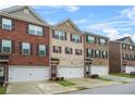 A row of townhomes with brick and siding exteriors, showcasing individual garage spaces and well-maintained landscaping at 3030 Westpoint Cir, Snellville, GA 30078