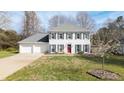 A well-maintained white home with a two-car garage and a vibrant red front door at 1011 Dogwood Forest Ne Dr, Marietta, GA 30068