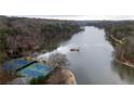 Aerial view of lake with tennis courts near the shore surrounded by trees at 330 Teal Ct, Roswell, GA 30076