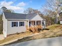 Charming single story home with gray siding, blue shutters and wood porch at 122 S Mill Creek Ct, Woodstock, GA 30188