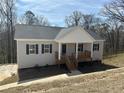 Charming single story home with gray siding, dark shutters and wood porch at 122 S Mill Creek Ct, Woodstock, GA 30188