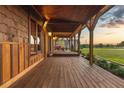 Expansive covered porch featuring wood decking, timber supports, and views of the surrounding landscape at 1694 Mount Bethel Rd, Mcdonough, GA 30252