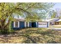 Inviting blue home with lush green lawn and mature trees at 2645 Trotters Walk Trl, Snellville, GA 30078