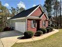 A well-maintained home featuring a brick facade, black shutters, and an attached two-car garage at 401 Carrie Kathleen Ter, Carrollton, GA 30116