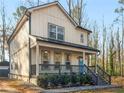 Charming home featuring a welcoming front porch, neutral siding, and a pop of color with its bright blue front door at 741 Se Knox Se Dr, Atlanta, GA 30315