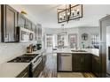 Modern kitchen featuring stainless steel appliances, quartz countertops, and dark wood cabinets at 949 Tumlin Trce, Lawrenceville, GA 30045