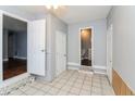 Bright tiled hallway leading to bathroom with a white door, neutral paint, and white trim at 491 Bolton Nw Rd, Atlanta, GA 30331