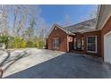 View of the driveway, lawn, and the red brick facade of this attractive home at 5060 Governors Walk Dr, Canton, GA 30115