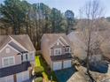 Aerial view of a home nestled among mature trees, featuring neutral siding and an attached two-car garage at 946 Gardenia Curv, Canton, GA 30114