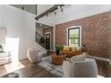 Bright living room with exposed brick wall, hardwood floors, high ceilings, and modern staircase at 6592 Factory Shoals Sw Rd, Mableton, GA 30126