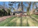 Street view of a quaint brick home with a bright red door, set on a grassy lot with mature trees at 2203 Knoll Dr, Decatur, GA 30032