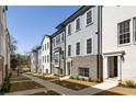 Street view of newly constructed townhomes featuring gray siding, brick accents, and manicured landscaping at 3165 Dogwood Dr # 107, Hapeville, GA 30354