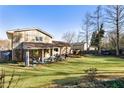 Expansive backyard featuring a covered porch, lush lawn, and mature trees at 6784 Tilton Ln, Peachtree Corners, GA 30360