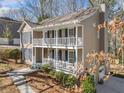 A beautiful two-story home featuring a double-decker porch with white railings and blue shutters at 1522 Wood Valley Dr, Marietta, GA 30066