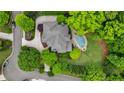 Aerial view of a home with a unique roof design, surrounded by lush greenery and a backyard pool at 2260 Wood Falls Dr, Cumming, GA 30041