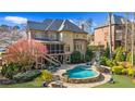 Beautiful backyard with a freeform pool, lush landscaping, and screened porch at 2260 Wood Falls Dr, Cumming, GA 30041