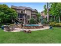 Gorgeous backyard with a stone-surrounded pool, umbrella, and outdoor seating on the well-manicured lawn at 2260 Wood Falls Dr, Cumming, GA 30041