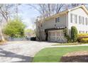 Side view of home with an attached garage, mature landscaping and concrete driveway at 3605 Wood Valley Ne Ct, Brookhaven, GA 30319