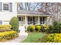Inviting covered front porch with a decorative door and charming landscaping at 3605 Wood Valley Ne Ct, Brookhaven, GA 30319