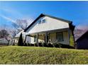 Inviting two-story home featuring a cozy front porch, lush green lawn, and black trim at 1583 Elixir Sw Ave, Atlanta, GA 30314